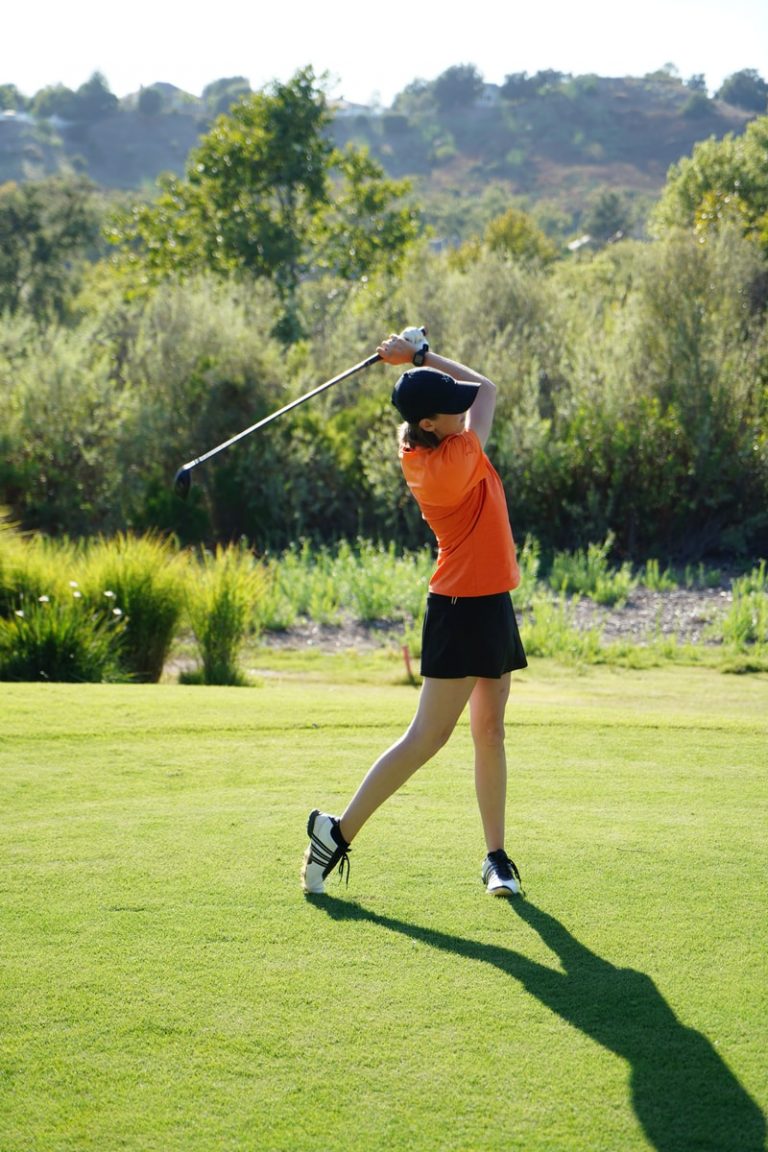 Golf pour les femmes Un adolescent faisant un swing au Golf